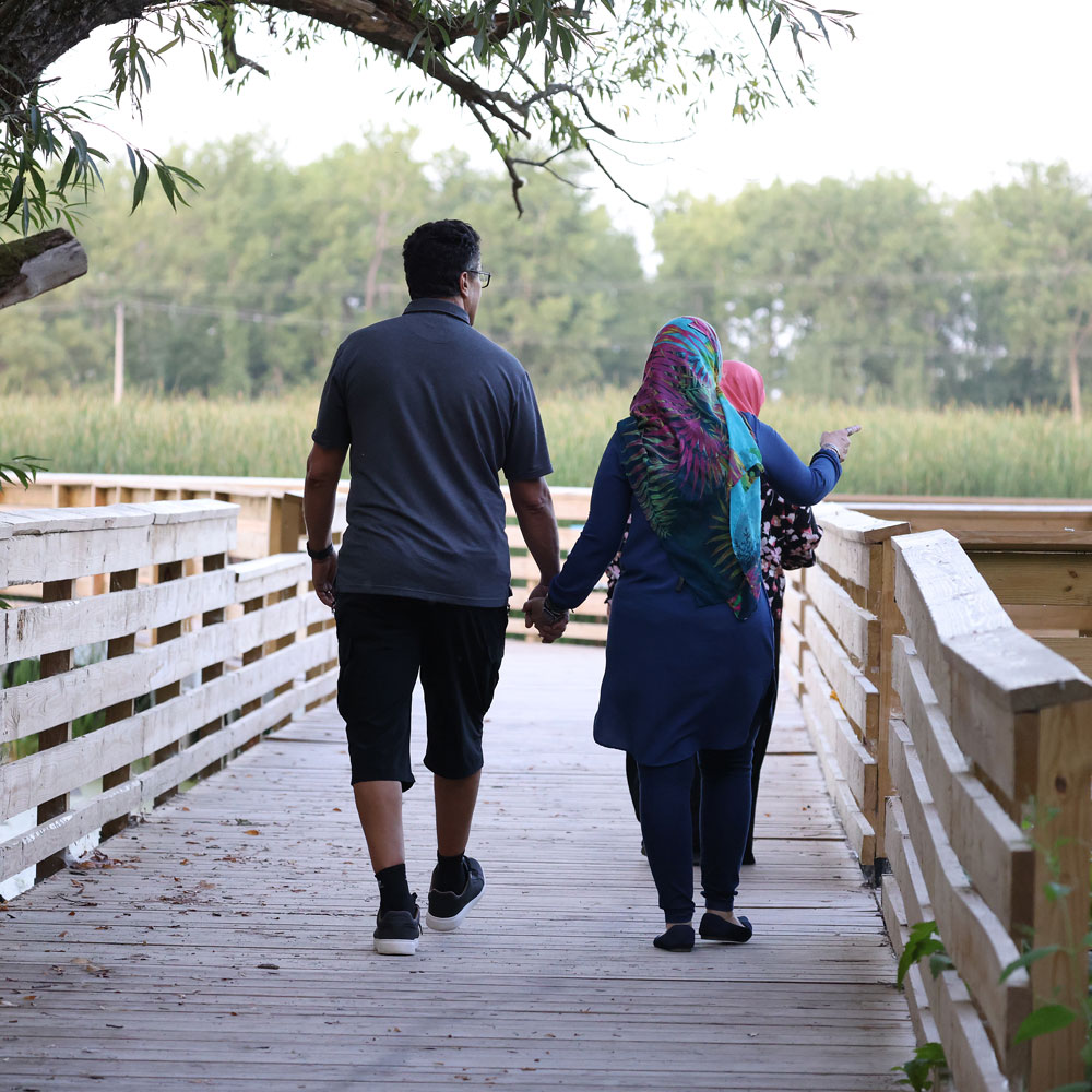 Couple holding hands walking down accessibility trail